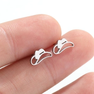 Detailed close-up of a silver cowboy hat stud earring held between fingers for size reference
