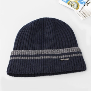 Detail of navy knit beanie featuring grey stripes and a silver sport metal logo
