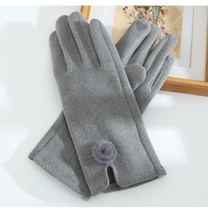 Detailed close-up of gray thermal gloves featuring decorative pom-pom and plush texture