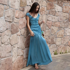 Détail de la robe bleue à col en V avec plis élégants et texture de tissu doux