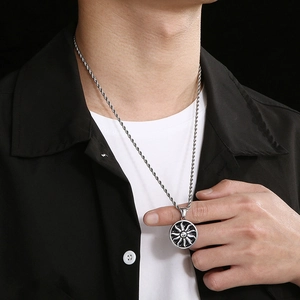 Gros plan d'un collier pour homme avec pendentif soleil et chaîne torsadée sur chemise