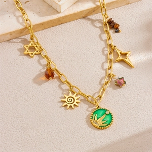 Gold chain necklace featuring green oil drop sun charm and celestial star pendants