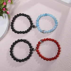Detail of magnetic couple bracelets with crown charms and natural stone beads