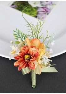 Detailed view of handmade orange daisy boutonniere with green leaves and ribbon wrap