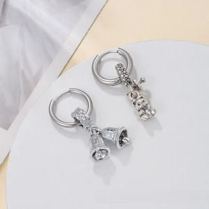Macro shot of silver retro hoop earrings with asymmetric bear and bell charms