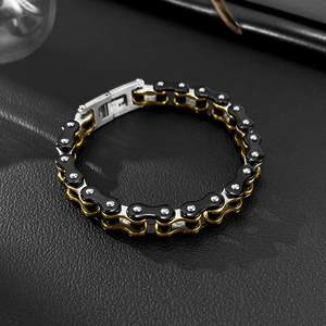 Detailed close-up of punk style black and gold stainless steel motorcycle chain bracelet