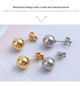 Macro shot of gold and silver ball stud earrings in polished stainless steel