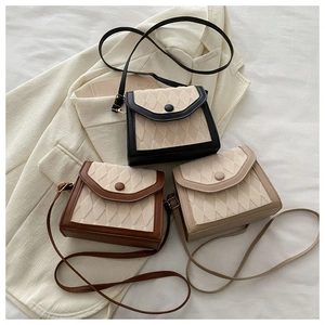 Quilted crossbody bags in black, brown and beige shown on a white blazer background