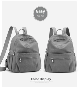 Detail view of two grey casual nylon backpacks with zippers and side pockets on white back
