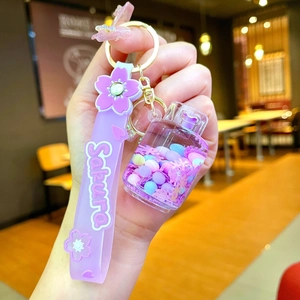 Detailed close-up of a purple Sakura silicone wristband and drifting bottle keychain charm