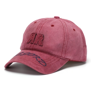Close-up of vintage washed red cotton fabric with detailed double R embroidery on the cap