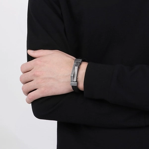 Men's black braided leather bracelet with industrial silver metal accents on wrist