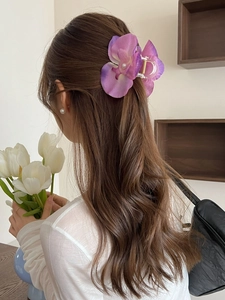 Detail of a large purple orchid hair claw clip with silk petals and pearl centerpiece
