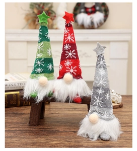 Close-up of three festive Christmas gnomes in knitted hats on a warm wooden background