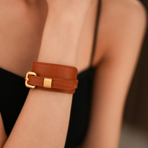 Detailed macro view of the brown leather bracelet with golden buckle and neat stitching