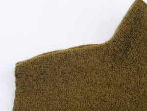 Close-up of olive brown chunky knit fabric showing soft mohair texture and long plush fibers