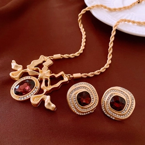 Vintage gold necklace and earring set with dark red gemstones and sparkling rhinestones