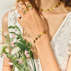 Nahaufnahme eines goldenen Kleeblatt-Schmucksets mit Halskette Armband und Ring