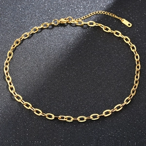 Detail of a golden stainless steel curb chain necklace with lobster clasp on black background
