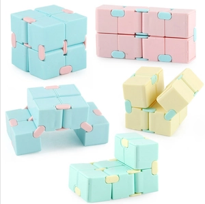 Fidget infinity cubes in blue, pink, and yellow plastic showing various folded shapes