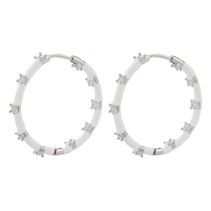 Detailed macro view of white enamel hoop earrings featuring micro-paved cubic zirconia stones