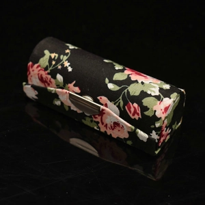 Macro shot of silk lipstick case with pink floral patterns and silver metal clasp