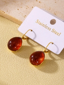 Macro shot of amber resin teardrop earrings with gold stainless steel hooks on display card