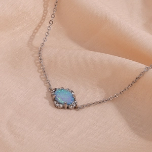 Vue macro d'un collier avec pendentif opale ovale argenté et bordure en strass brillant