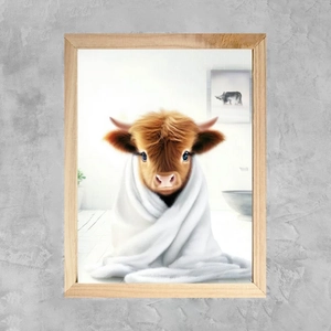 Detail of whimsical Highland cow canvas print in frame hanging on grey concrete wall