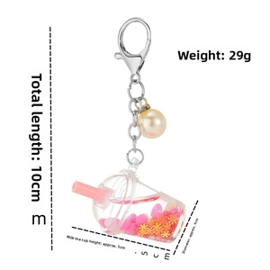 Detail of pink liquid boba tea keychain with heart sequins and white pearl bead charm