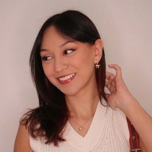 Elegant gold bow necklace and earrings set with pearls and diamonds on a model