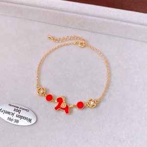 Vue macro du bracelet poney doré avec émail rouge et breloques de pièces de monnaie