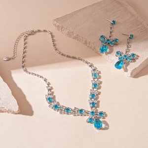 Detail of luxury zircon bow necklace and teardrop earrings set with blue gemstones