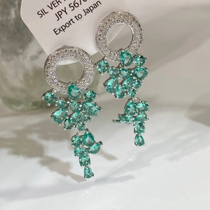 Vue détaillée des boucles d'oreilles en argent avec zircon et gouttes de cristal vert