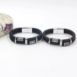 Detail of double-layer braided leather bracelets in black and brown with magnetic metal clasps