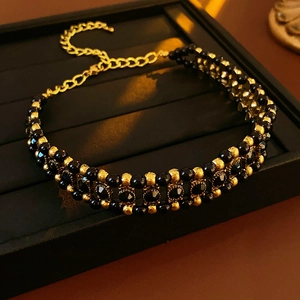 Detail of gold beads and black faceted stones on a double-layer adjustable choker