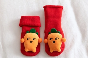 Detailed macro view of red baby floor socks with thick cotton terry and carrot decor