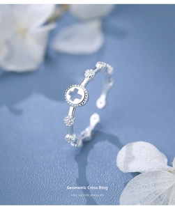 Detailed view of hollow cross ring in S925 silver with elegant floral background