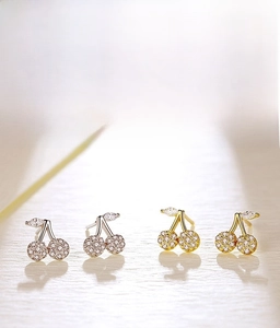 Detail of cherry stud earrings with pavé crystals in silver and gold finishes