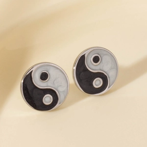 304 stainless steel yin yang stud earrings with silver edges on soft beige fabric