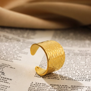 Detailopname van een brede gouden open ring met een vintage gehamerde textuur