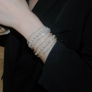 Close-up of elegant multi-layer bracelet with pearls and sparkling rhinestones on model