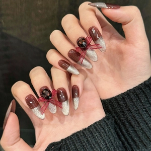 Faux ongles stiletto faits main rouge cerise œil de chat avec nœud et pierre précieuse