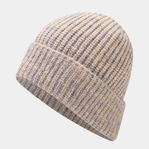 Detailed close-up of thick ribbed knit texture on a beige and grey striped beanie hat
