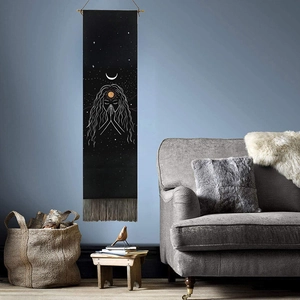 Macro detail of black bohemian lunar tapestry with white celestial art and fringed edges