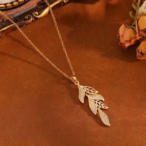 Elegant gold leaf pendant necklace with crystals and hollow leaves on a chain