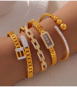 Close-up of a four-piece gold titanium steel bracelet set featuring crystal accents on a model