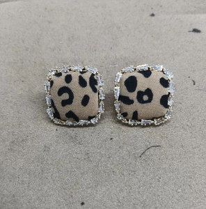 Detailed view of leopard print fabric earrings with sparkling zircon stone borders