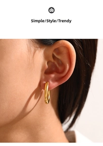Close-up of matte golden hoop earring with a minimalist satin finish worn by model