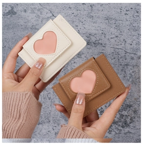 Close-up of cream and brown PU leather mini wallets with heart-shaped window details